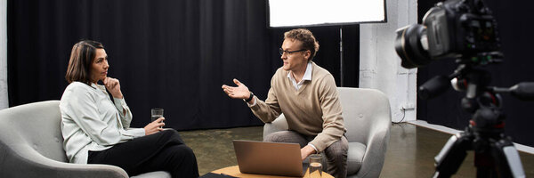 A journalist engages with a specialist in a studio, discussing important topics during their interview.