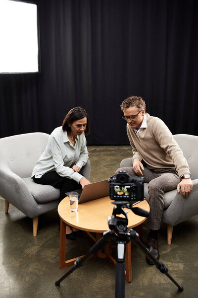 A middle-aged journalist interviews a professional specialist, fostering an insightful discussion in a modern studio.