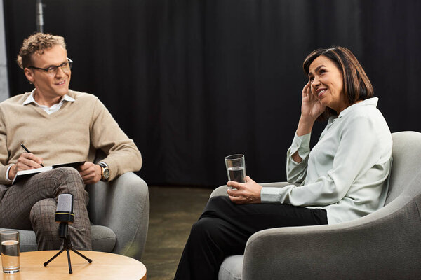 A professional journalist interviews a knowledgeable woman, exchanging ideas in a dynamic discussion.