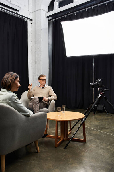 A journalist and a professional specialist share insights during an interview in a stylish studio.