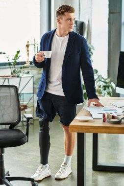 A young and handsome businessman with a prosthetic limb enjoys a coffee break in a contemporary office. clipart