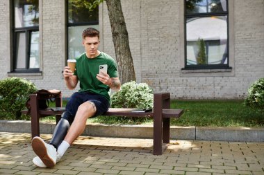 Protez bacaklı yakışıklı genç bir adam bir bankta rahatlar ve akıllı telefonuyla meşgul olur..