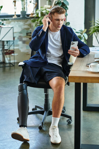 A young professional with an artificial limb engages with his smartphone in a contemporary workspace.