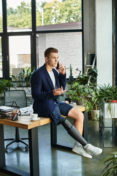 Молодой бизнесмен с протезной ногой уверенно ведет беседу, сидя за своим столом.