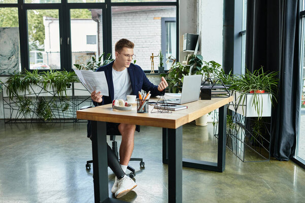 Молодой профессионал с протезной конечностью фокусируется на задачах в стильном офисе, охватывая разнообразие рабочих мест.