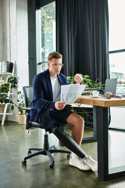Молодой бизнесмен с искусственной конечностью рассматривает важные документы в современном офисе.