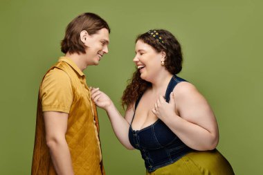 A young plus size woman shares a joyful moment with her male friend, both smiling cheerfully. clipart