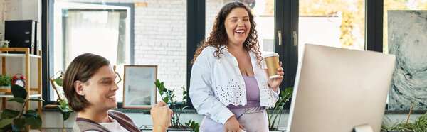 A young plus size woman laughs with a male friend in a cozy workspace over coffee.