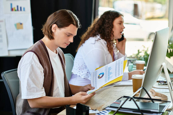 A young plus size woman talks on the phone as her friend reads important papers at their workspace.