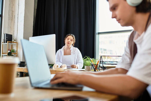 Молодая женщина плюс размер вдумчиво взаимодействует со своим другом-мужчиной, работая вместе.