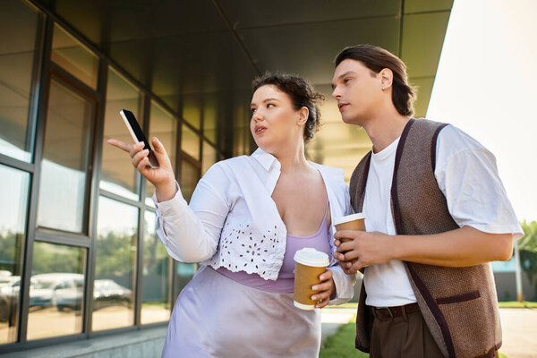 Молодая женщина плюс размер болтает оживленно со своим другом-мужчиной, потягивая кофе.