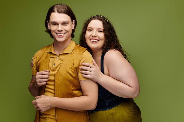 A happy young plus size woman embraces her male friend with joy, showcasing friendship.