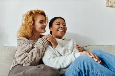 İki kadın evdeki rahat bir kanepede dinlenirken birbirlerine eşlik etmekten zevk alırlar..