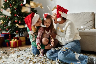 Neşeli bir aile yerde toplanıyor, bayram süslemeleriyle çevrili neşeli anların tadını çıkarıyorlar..