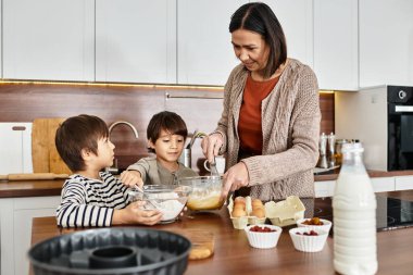 Bir büyükanne, Noel 'den önce güzel anılar yaratarak iki torunuyla yemek pişirme zevkini paylaşır..