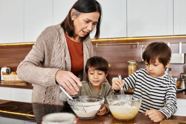 Bir büyükanne, torunlarına Noel yaklaşırken sıcak mutfaklarında birlikte pişirme becerileri öğretir..