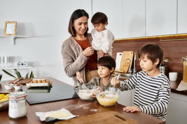 Sıcak bir mutfakta, bir büyükanne Noel 'den hemen önce torunlarıyla yemek yapmaktan zevk alır..