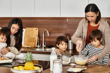 Neşeli bir Asyalı aile, Noel şenliklerinden önce birlikte yemek yapmayı ve tatlı ikramlar sunmayı sever..