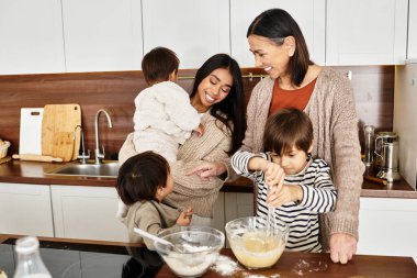 A joyful family prepares festive treats in a cozy kitchen, fostering love and togetherness during Christmas. clipart