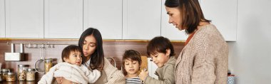 A joyful family gathers in a modern kitchen, preparing festive treats together before Christmas. clipart