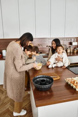 Neşeli bir aile sıcak mutfaklarında bayram ziyafeti hazırlıyor, çocuklar da hevesle pişirme eğlencesine katılıyor..