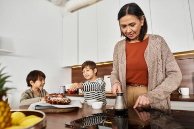 Neşeli bir aile, tatil ruhunu kucaklayarak, sıcak mutfaklarında birlikte şenlikli ikramlar pişirmeyi sever..