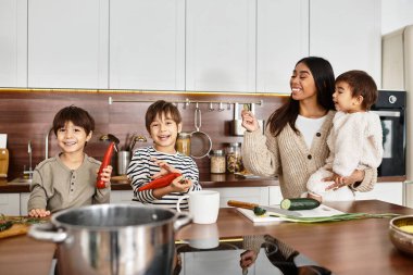 Mutlu bir aile, mutlu çocuklar ve yetişkinlerin mutfak zamanlarının keyfini çıkardıkları tatillerde yemek pişirir..