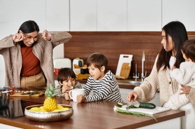 Neşeli bir aile tatil yemeklerinin keyfini çıkarırken, çocuklar meşgul ve yetişkinler neşeli bir şekilde ziyafet hazırlıyor..