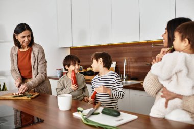 Mutlu bir Asyalı aile, sıcak mutfaklarında birlikte şenlikli yemekler pişirmekten hoşlanır..