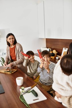 Winter holiday spirit shines as a happy Asian family joyfully prepares baked treats together in their kitchen. clipart