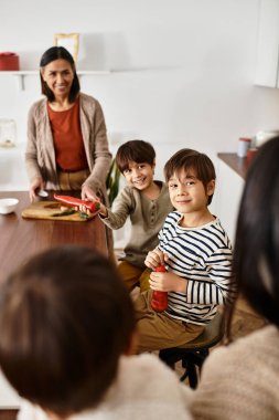 Neşeli bir Asyalı aile modern bir mutfakta toplanıyor, bayram için ziyafet hazırlıyorlar..