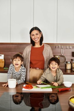 Neşeli bir aile lezzetli bayram yemekleri pişiriyor, modern mutfaklarında kahkaha ve şenlik ruhuyla dolu..