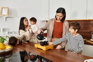 Neşeli bir aile şık mutfaklarında eğleniyor, çay yapıyor.