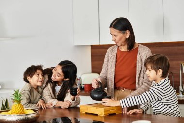 Neşeli bir aile, çağdaş mutfaklarında çay yapmayı sever..