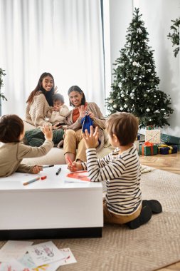 Neşeli bir Asyalı aile, bu kış güzel dekore edilmiş bir Noel ağacıyla birlikte güzel vakit geçiriyor..