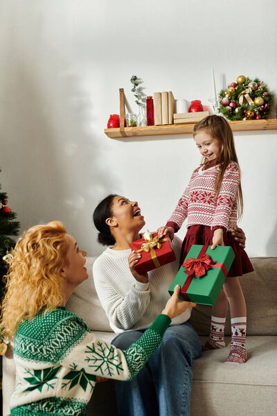 Теплый момент разворачивается, когда любящая пара делится подарками со своей очаровательной дочкой дома.