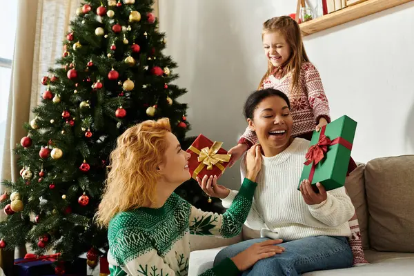 Sevgi dolu bir çift hediyelerini açarken Noel neşesini kızlarıyla paylaşıyor..