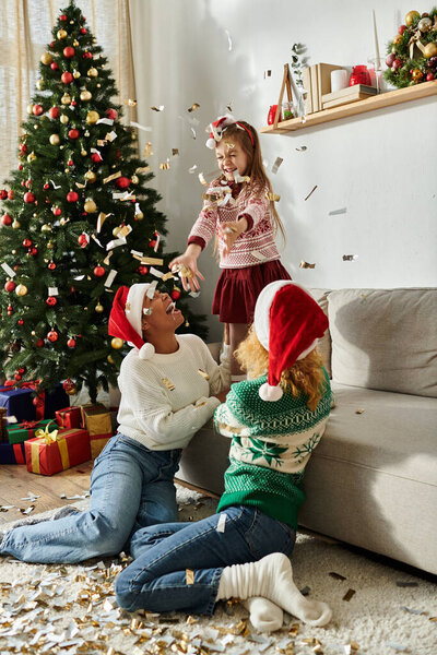 Играющий момент разворачивается, когда дочь бросает конфетти в окружении любимых.