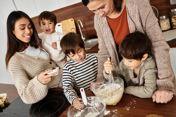 Восхитительный семейный момент разворачивается, как милые дети пекут со взрослыми на уютной кухне перед Рождеством.