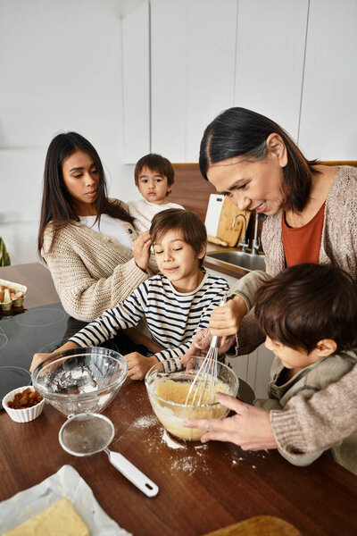 Веселая семья печет вместе, создавая праздничные угощения, наслаждаясь качеством времени перед Рождеством.