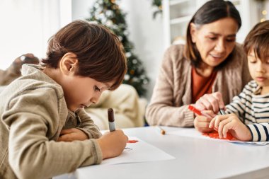 Neşeli bir aile, sıcak ve modern bir oturma odasında toplanır. Kış tatillerinde yaratıcı anların tadını çıkarırlar..