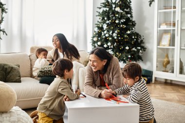 A happy family celebrates winter holidays together, creating cherished memories near their Christmas tree. clipart