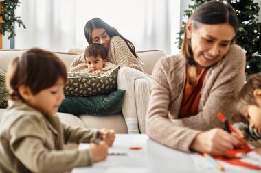 Mutlu bir aile, güzel dekore edilmiş bir Noel ağacının yanında birlikte vakit geçirmekten zevk alır, kahkahalarını paylaşır..