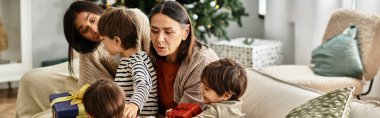 Mutlu bir ailenin Noel sabahı toplanıp, neşe ve hediyeleri paylaşması gibi kahkahalar modern oturma odasını doldurur..