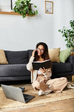 Memnun bir kadın yerde oturur, telefonda konuşur ve notlar alır..