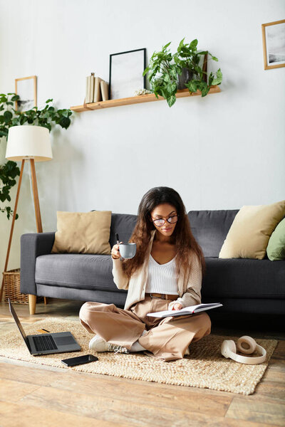 Sitting comfortably on a rug, a woman reads and sips her tea in a serene home environment.