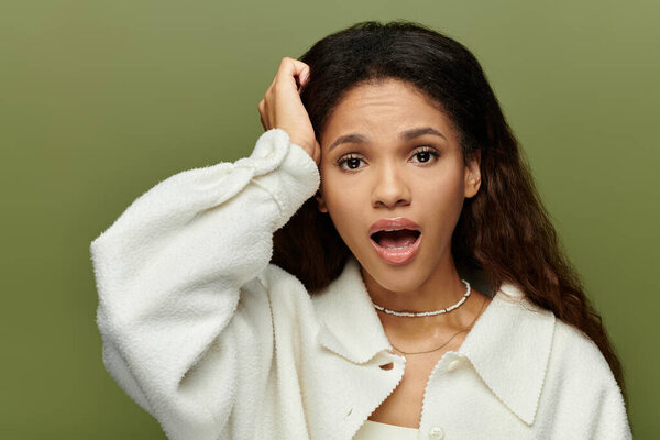 A stunning woman with flowing hair touches her head, radiating astonishment.