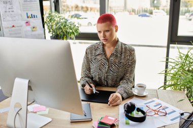 The bald woman attentively engages in her work at a modern desk filled with design materials. clipart