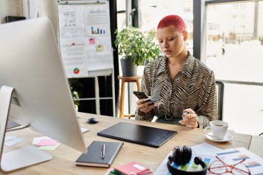 Kadın, modern ofis atmosferiyle çevriliyken akıllı telefonuna konsantre oluyor..