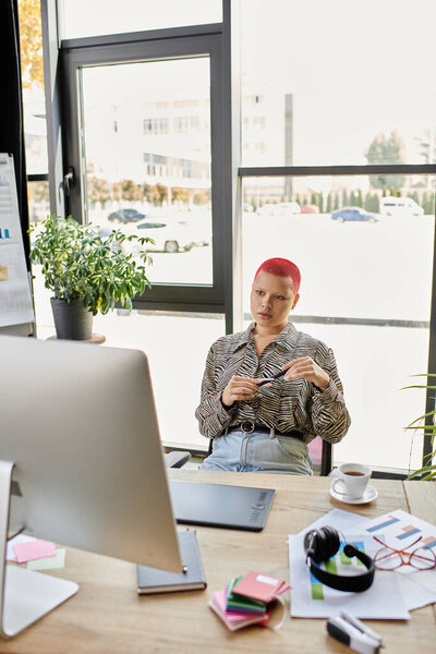 Лысая женщина в узорчатой рубашке рассматривает свой следующий шаг, сидя за столом.